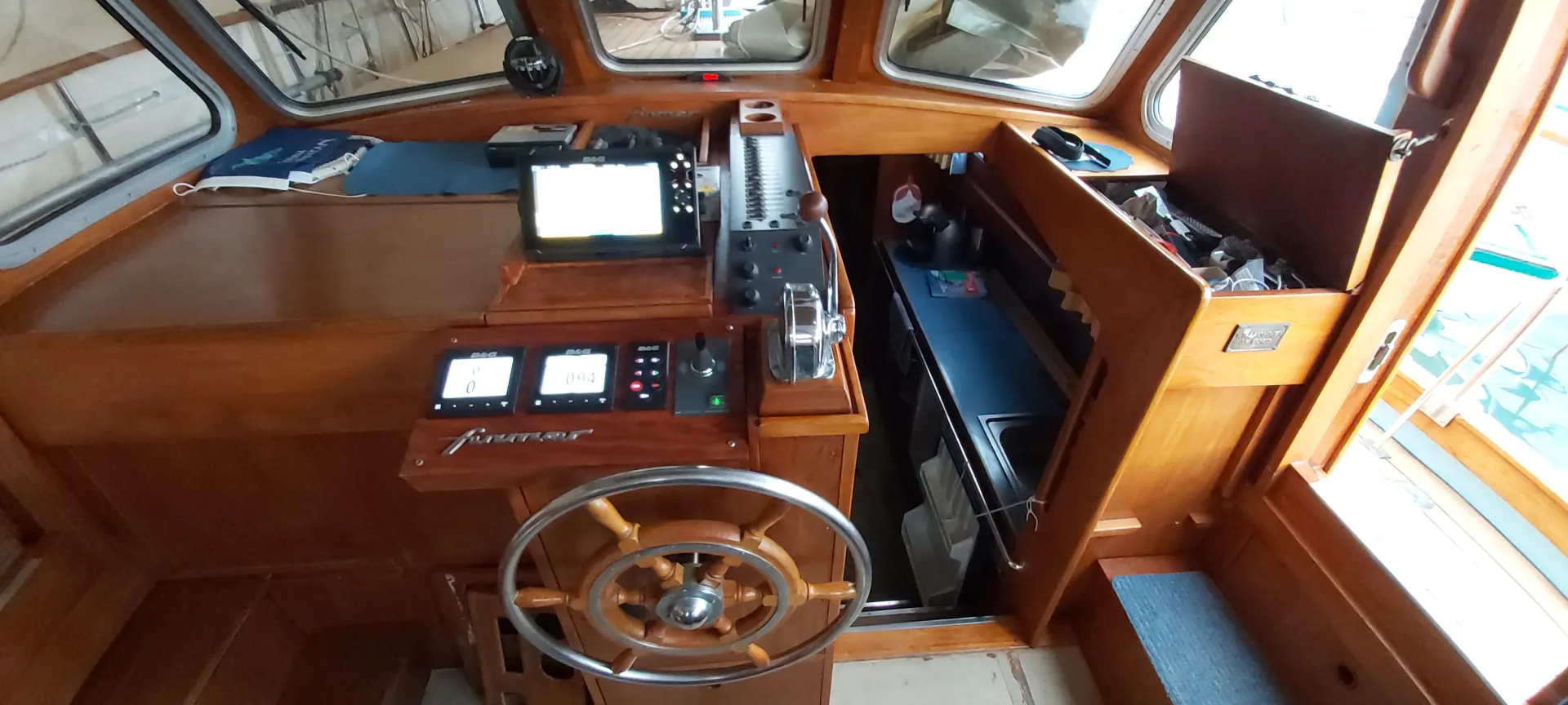 Übersicht des modernisierten Innencockpits mit Steuerrad, B&G-Anzeigen und Plotter auf historischem Furnier-Holz